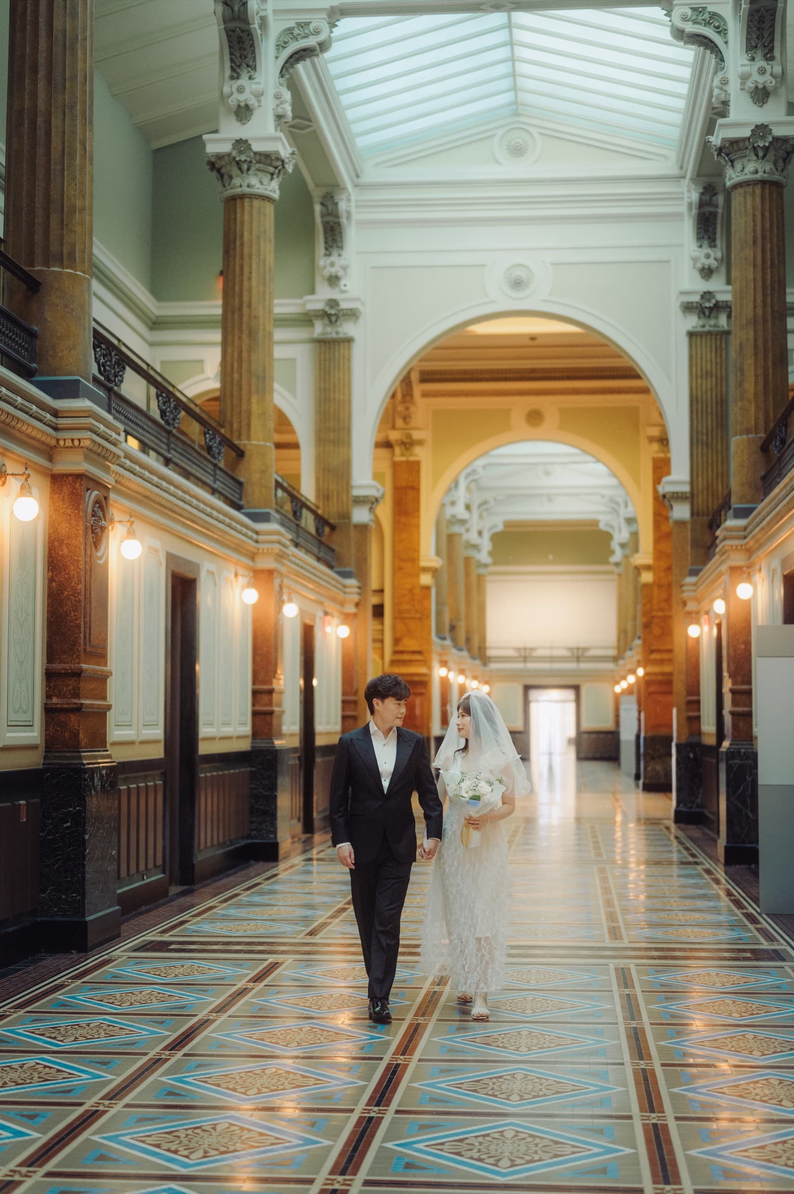 Couple walking through a grand hallway